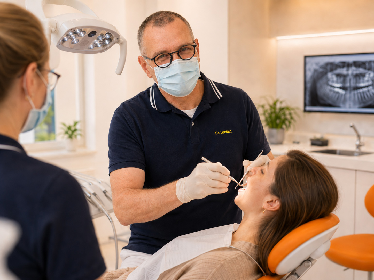 Moderne Zahnarztpraxis in Aktion Ein Zahnarzt, der Handschuhe und eine Maske trägt, untersucht in einer hell beleuchteten Zahnarztpraxis die Zähne eines Patienten, während eine Assistentin dabei zusieht. Im Hintergrund sind zahnärztliche Instrumente und eine Röntgenaufnahme zu sehen.